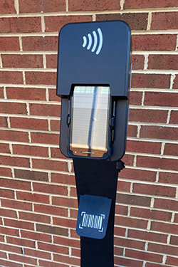 A black pedestal holds a tablet that will be used to scan digital tickets at Neyland Stadium The black scanner is positioned in front of a brick wall