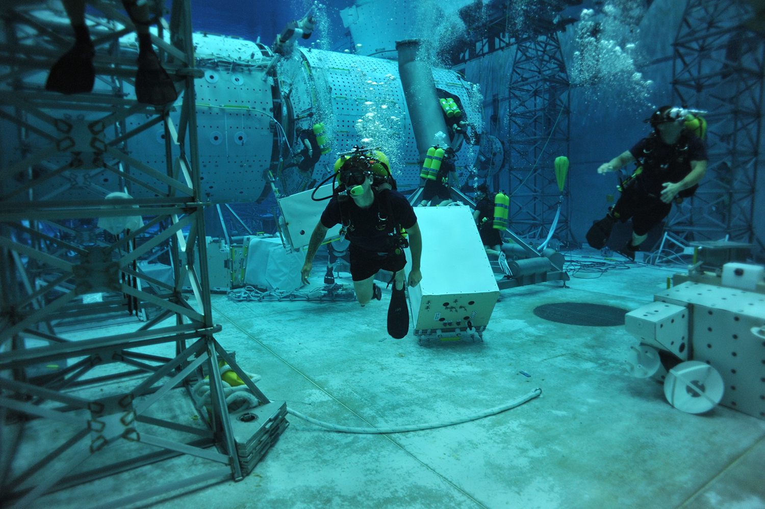 Alex Weber, center, swims through a dive tank at NASA's Neutral Buoyancy Laboratory in Houston, Texas. Weber, now a UT senior, was training NASA divers for future capsule recovery missions.